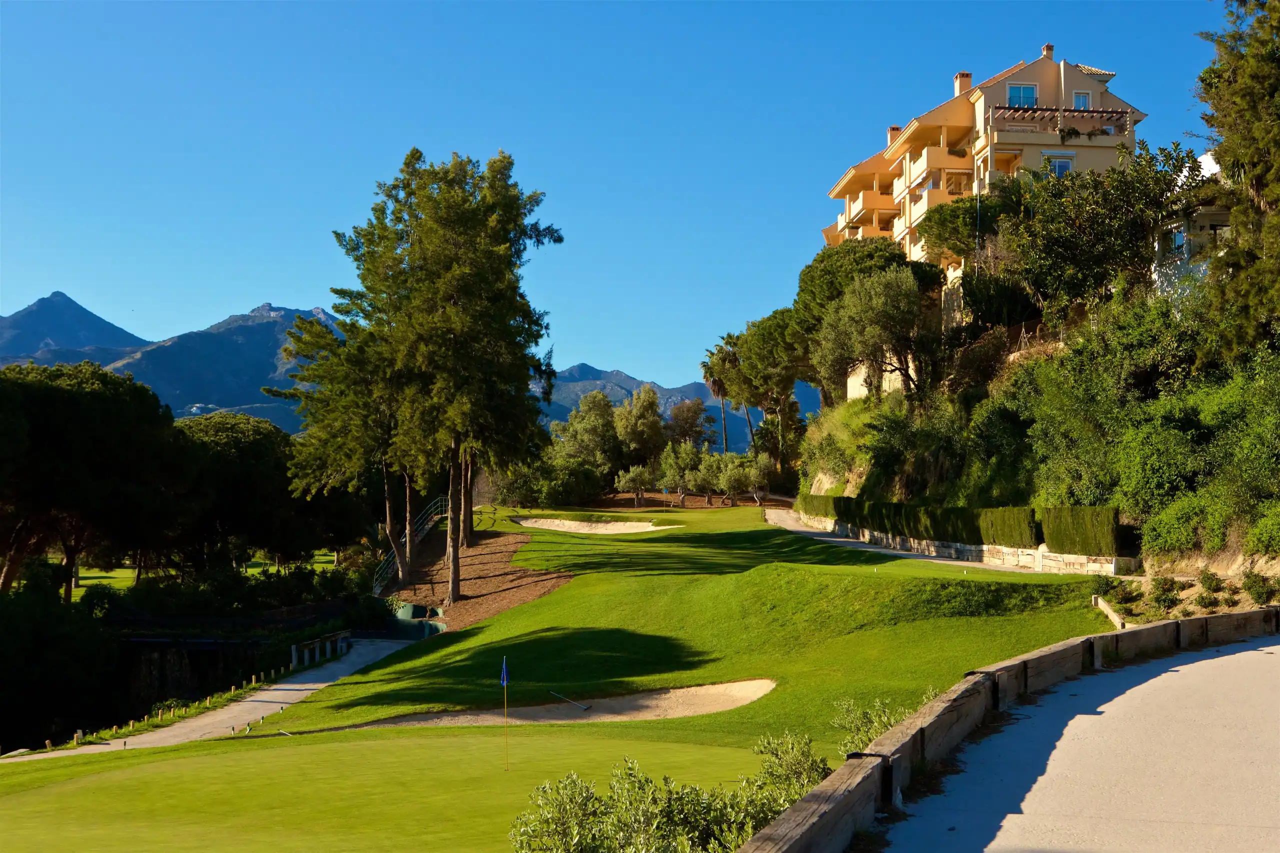 Golf course view in Marbella with lush greens and scenic mountain backdrop.